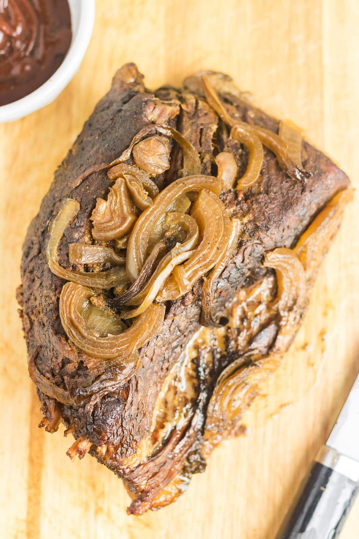 Brisket and onions resting on a cutting board.