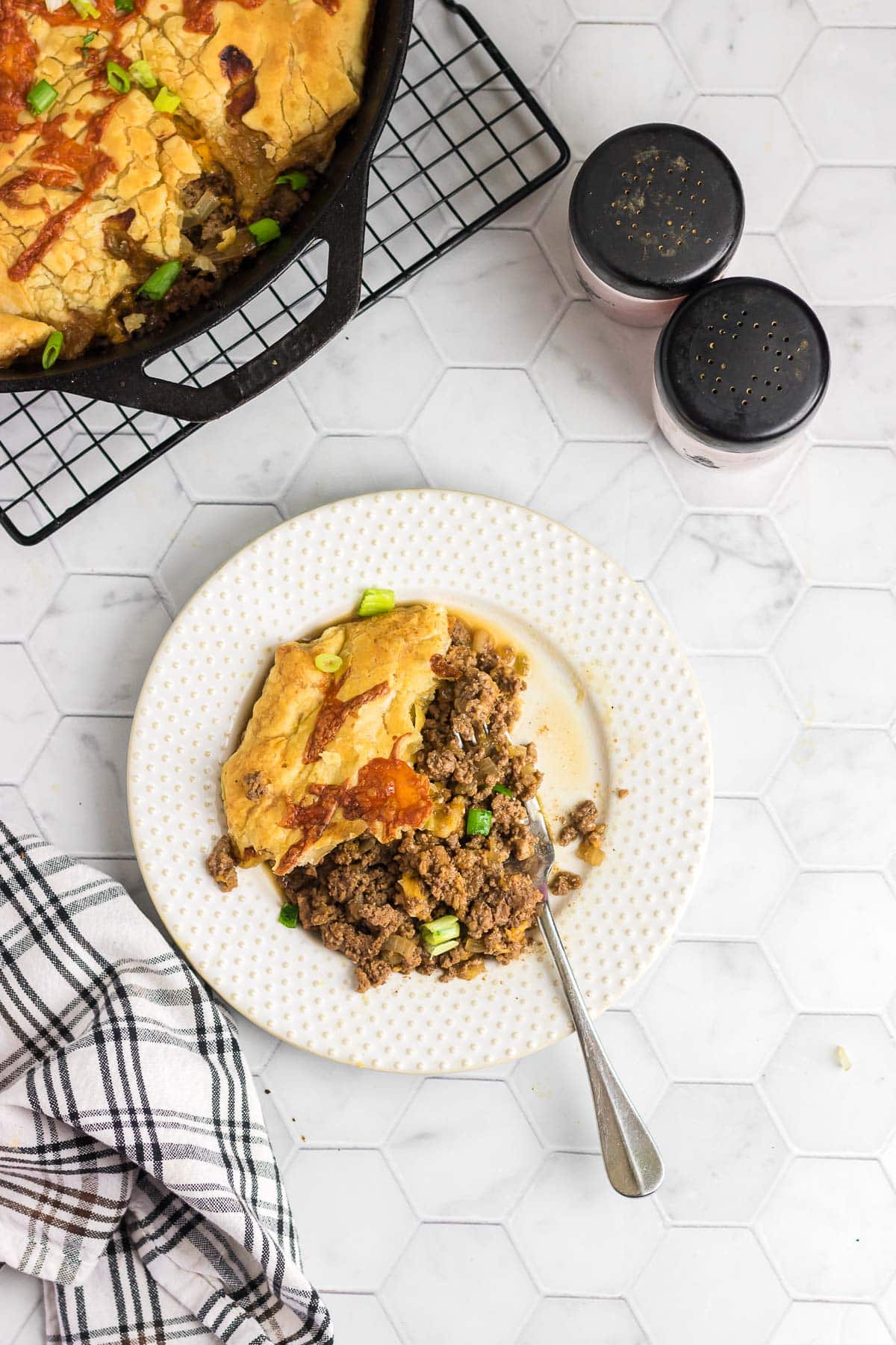 A scoop of puff pastry cheeseburger pot pie on a serving plate.