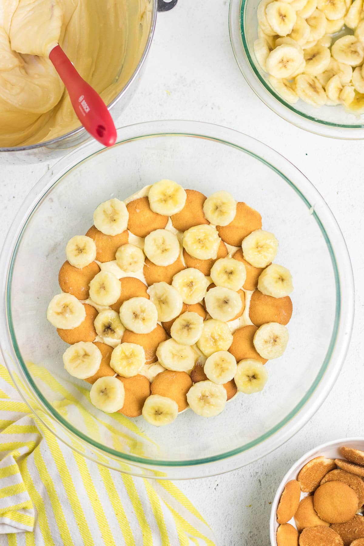 The first layers of pudding, Nilla wafers, and bananas in a bowl.