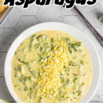 Overhead view of a bowl of creamed asparagus with title text overlay for Pinterest.