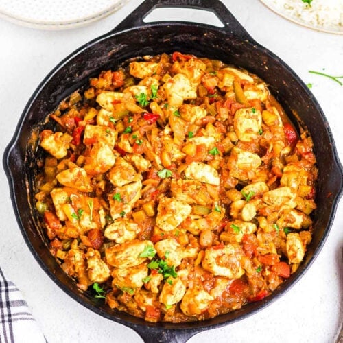 Overhead view of chunks of tender chicken in a tomato and pepper sauce.