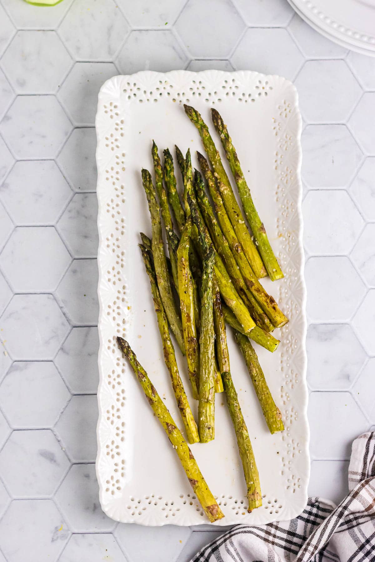 Roasted asparagus on a decorative serving platter.