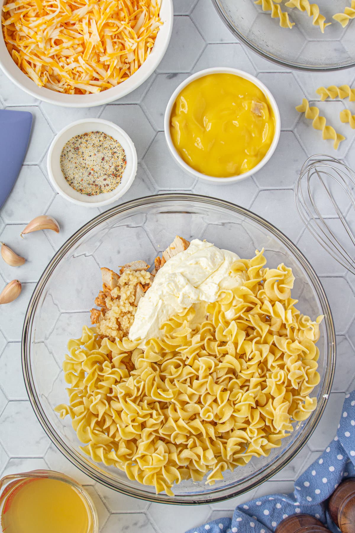 Noodles, butter, chicken, and cream cheese in a large mixing bowl.
