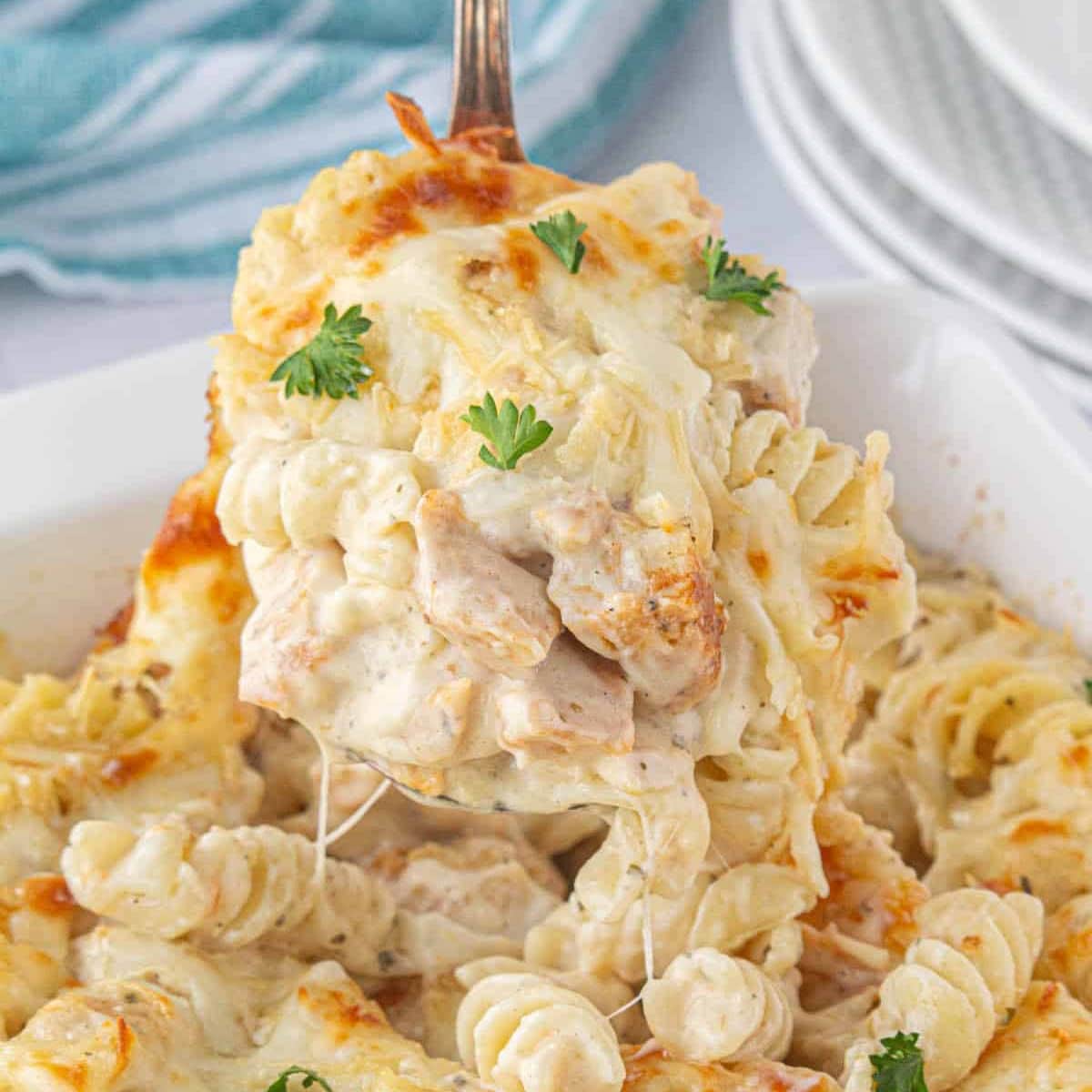 Cheesy, gooey garlic and parmesan chicken pasta bake being served.