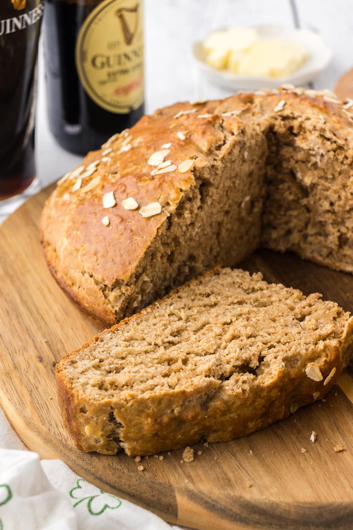 This image shows Guinness Irish Soda Bread on a cutting board with a slice of bread cut. 