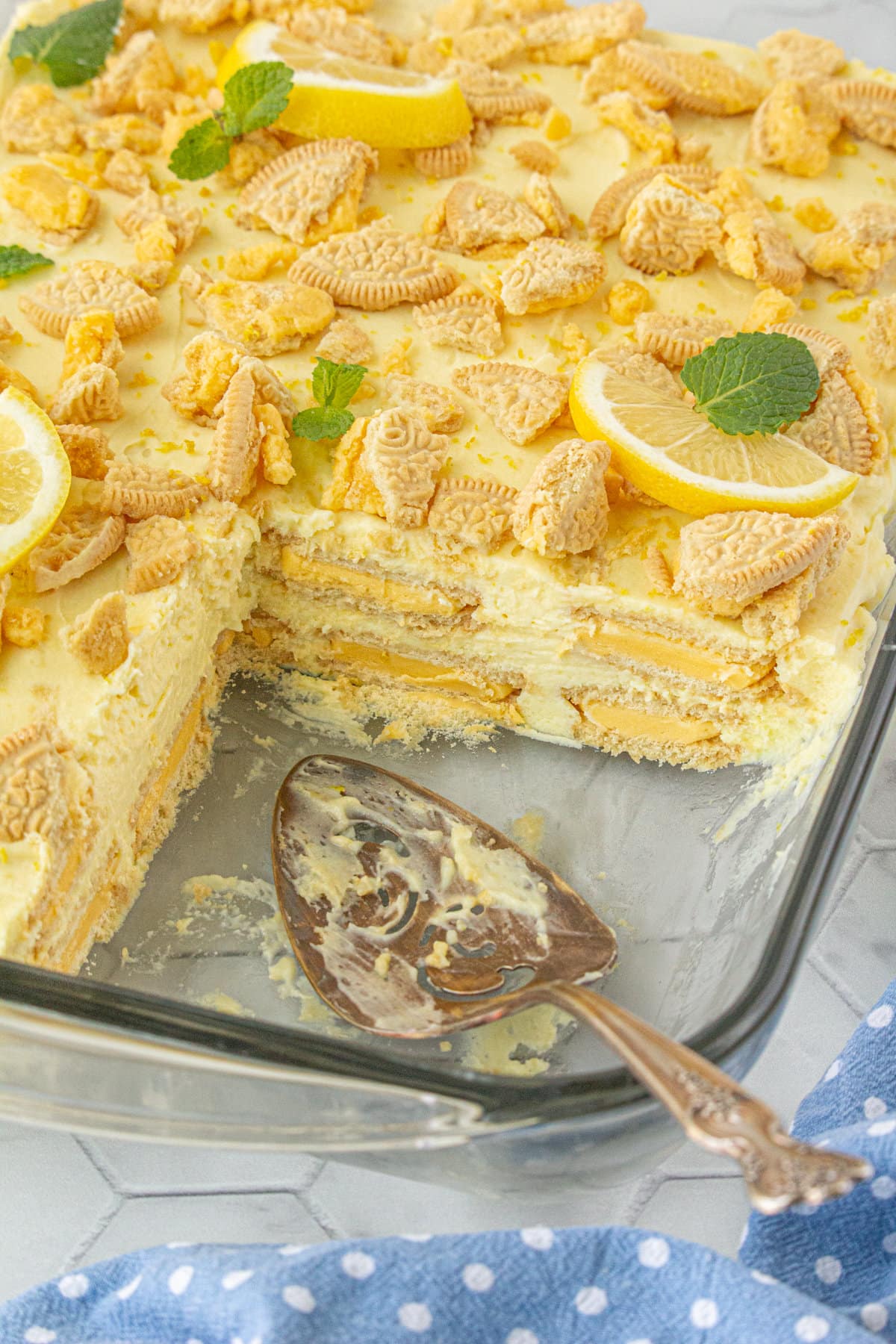 Lemon icebox cake in a pan with a slice removed so you can see the layers of cookies and cream.