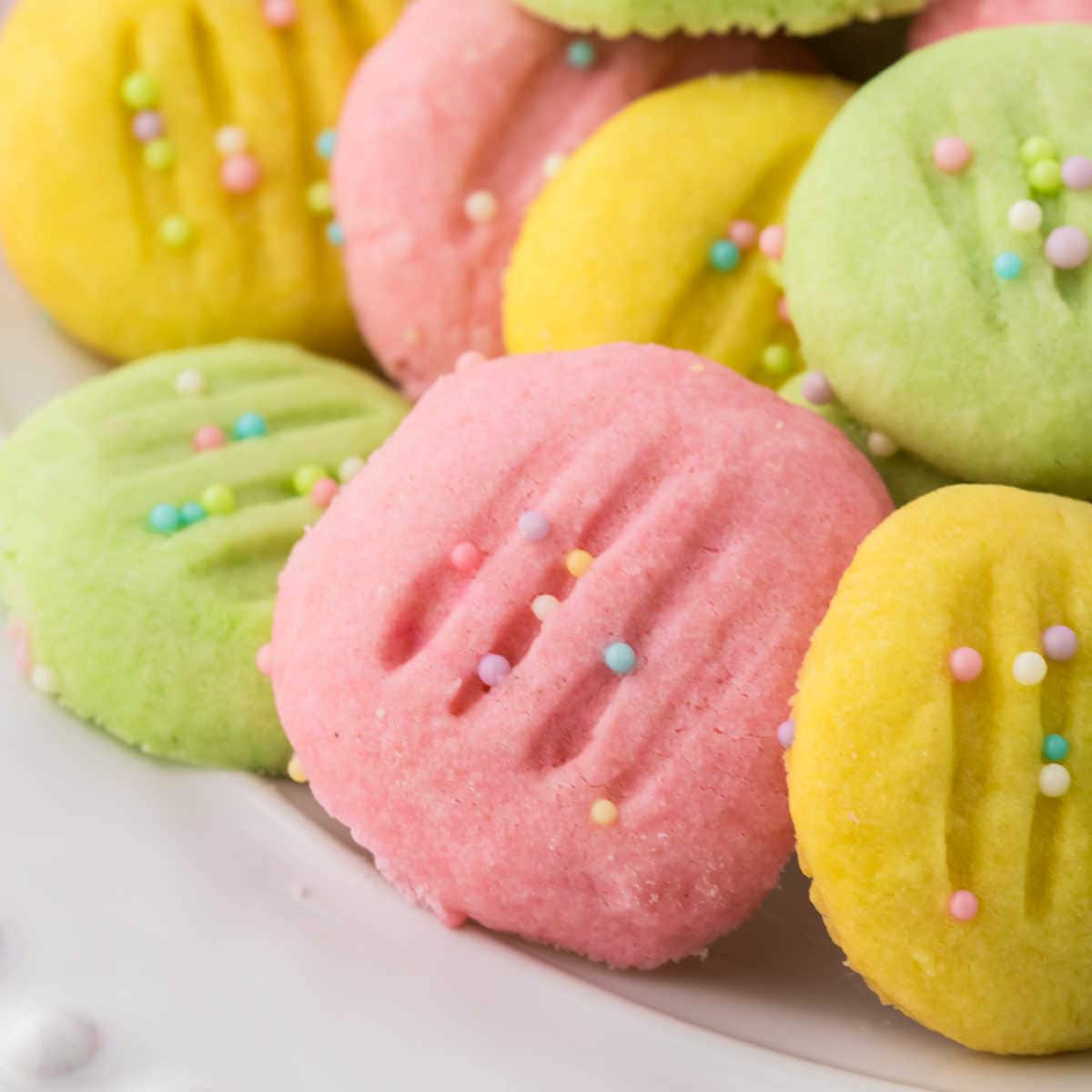 Closeup of meltaway cookies in pastel colors with sprinkles on top.