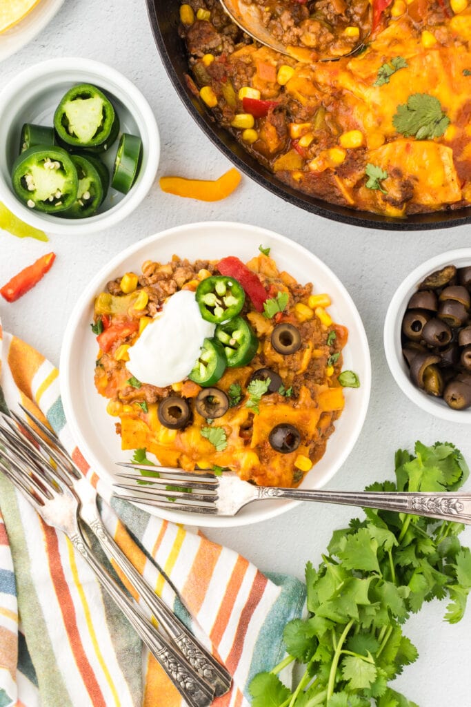 Overhead view of skillet tamale casserole being served on a white plate.