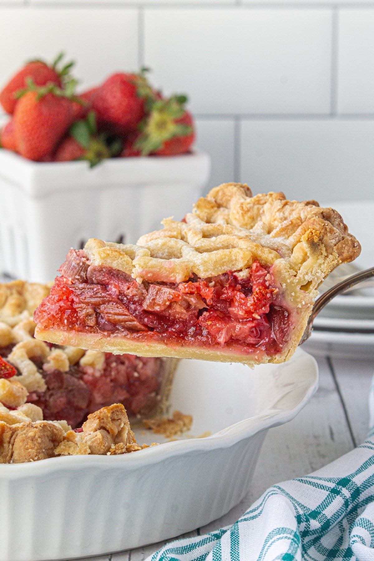 A slice of strawberry rhubarb pie being removed from the dish.