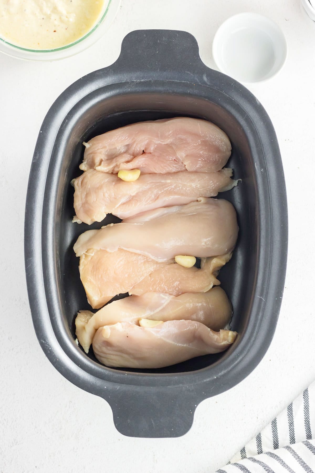 Add chicken and garlic to slow cooker.
