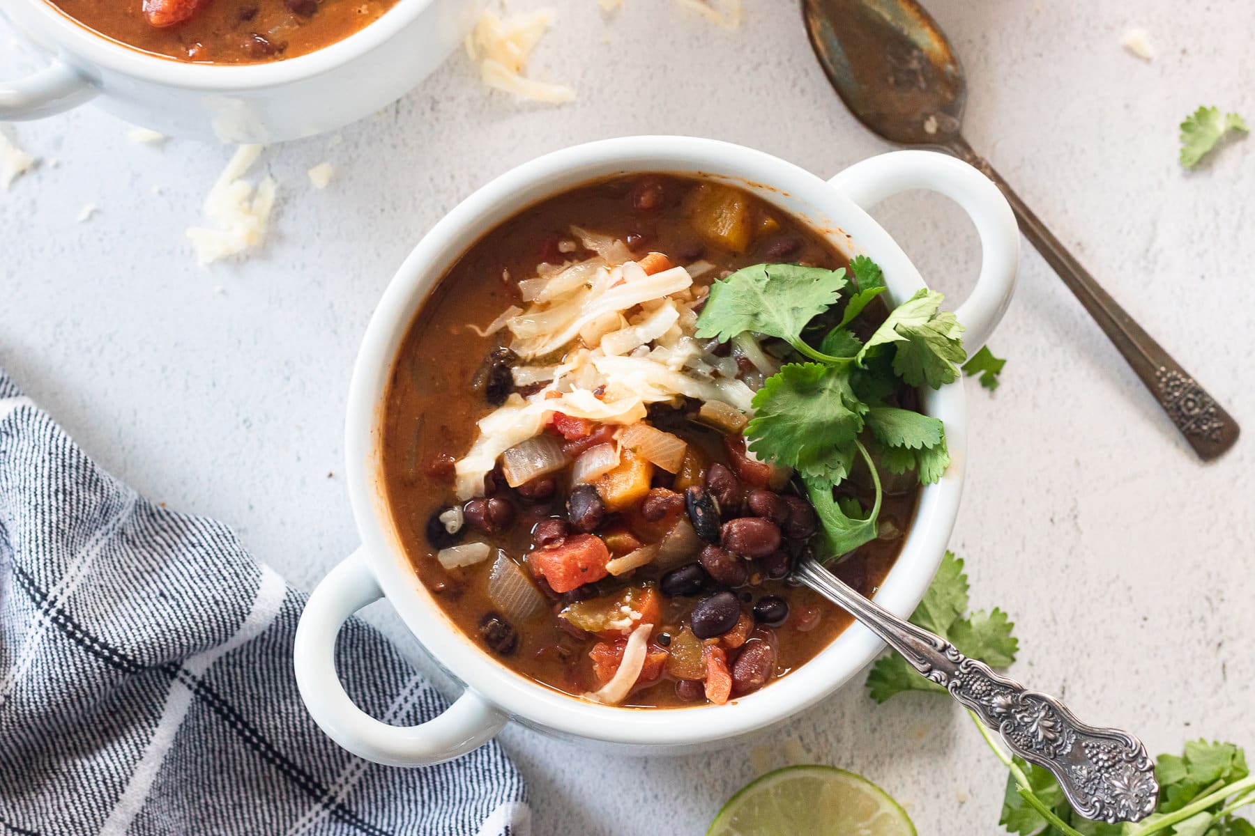 Overhead view of a white bowl with black bean soup in it.