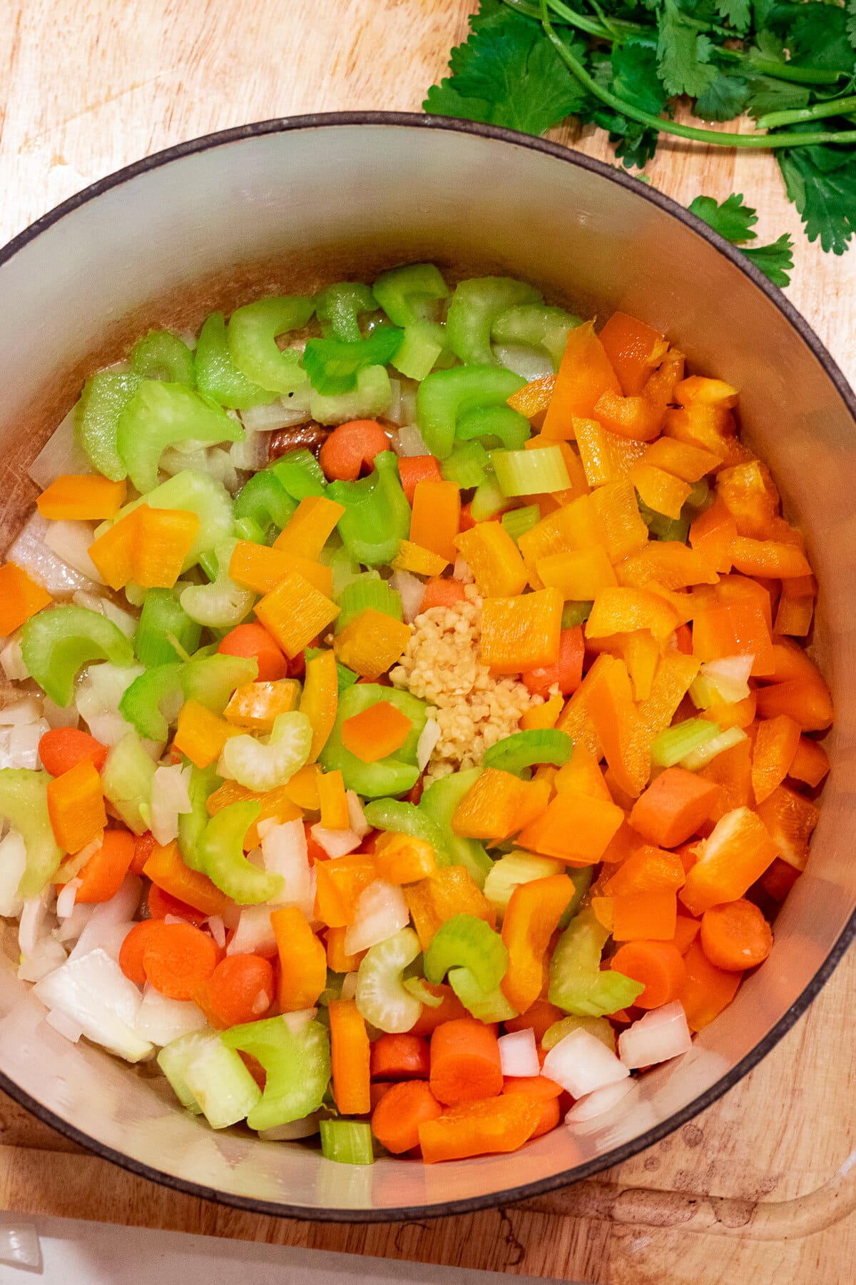 Vegetables being sauteed in a stockpot.