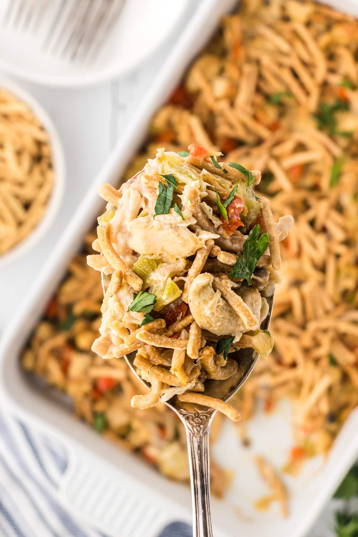 An up-close view of a scoop of chopstick tuna casserole on a serving spoon.