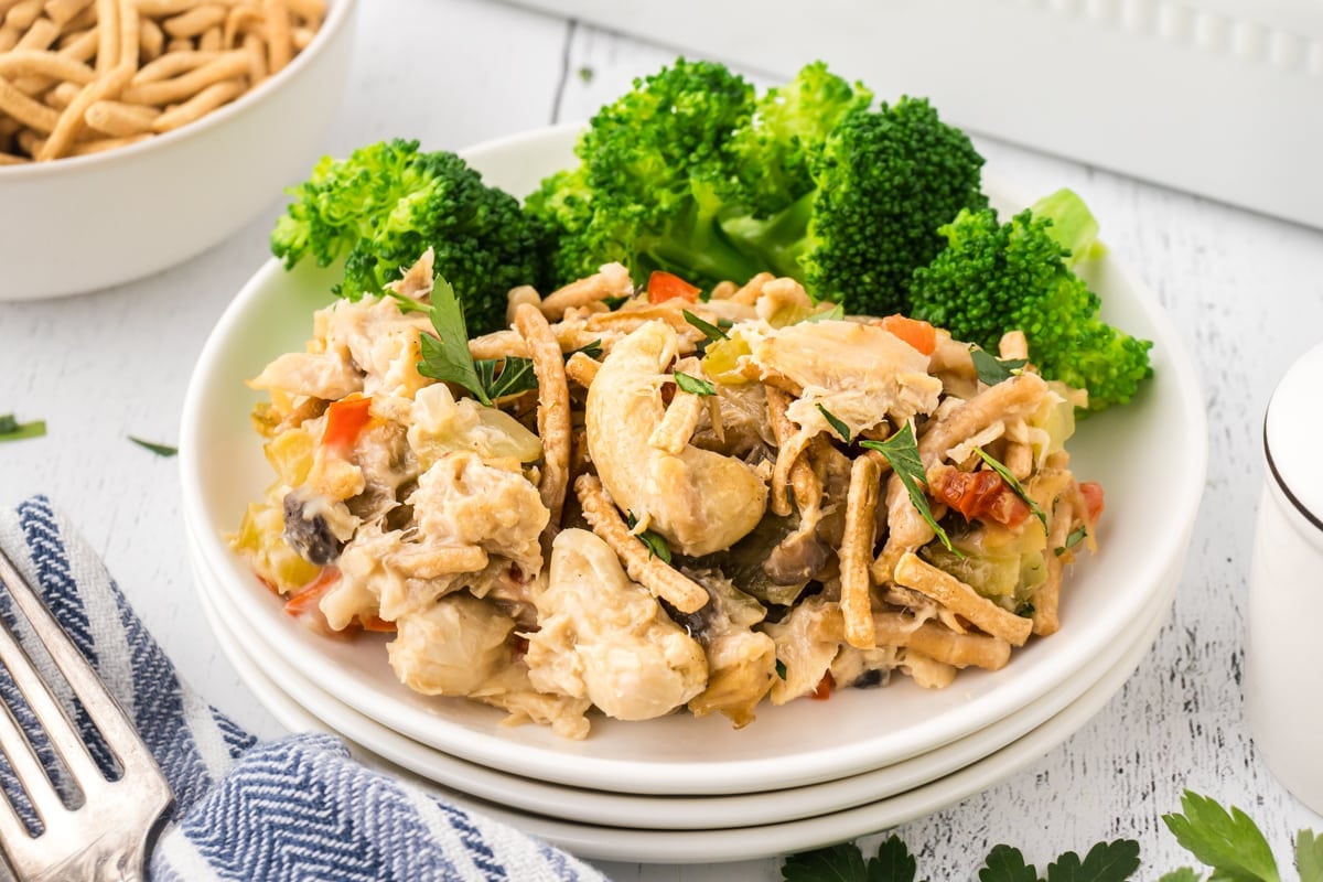Chopstick tuna casserole on a dinner plate with broccoli.