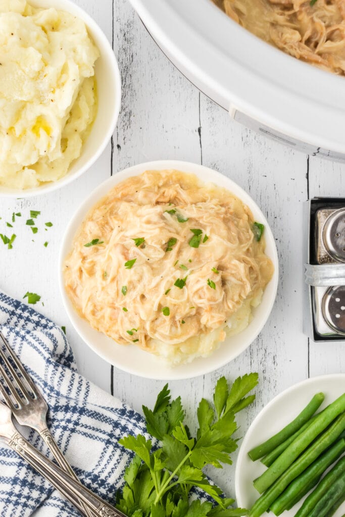 Overhead view of Crockpot chicken and gravy spooned over mashed potatoes.