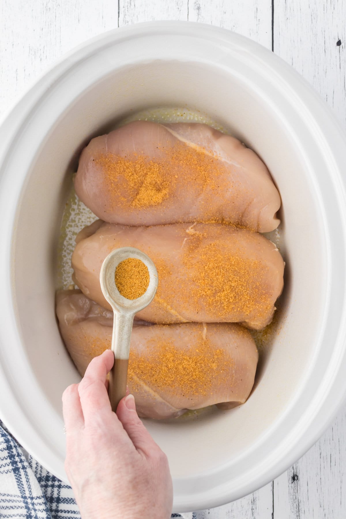 Raw chicken breast in the bottom of the crockpot.