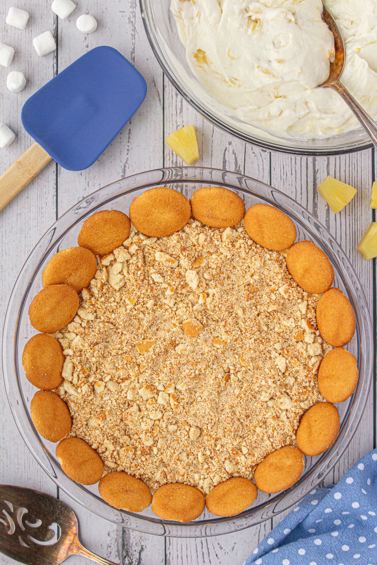 Cookie crumbs pressed into a pie plate with wafer cookies lining the edge.