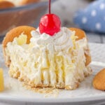 A slice of pineapple cream pie with a cherry on the top.