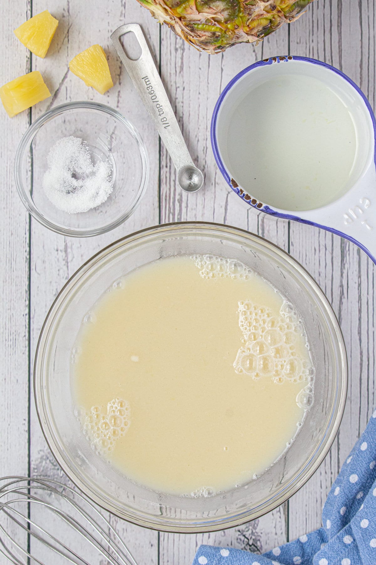 The sugar, flour, salt, and pineapple syrup in a mixing bowl.