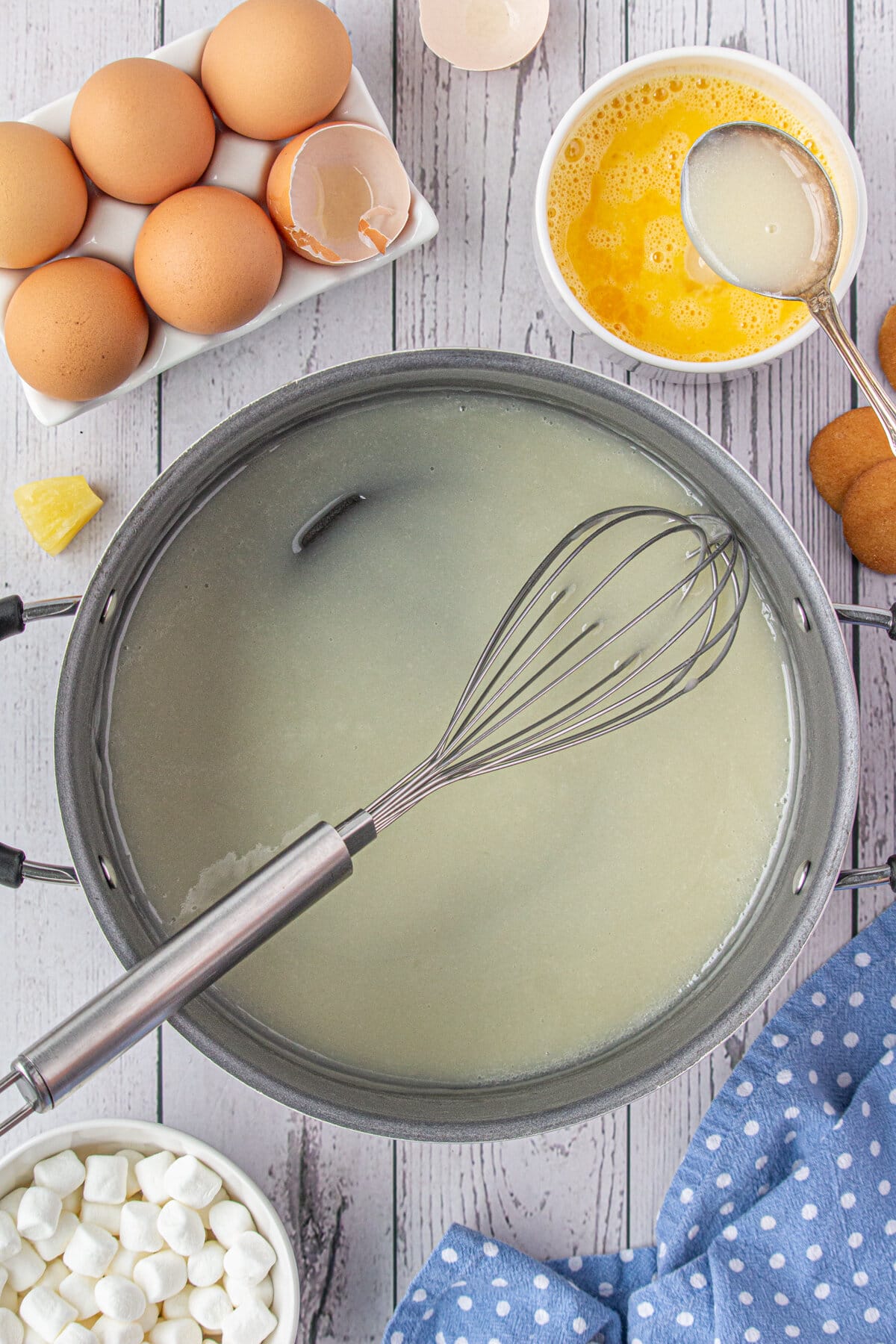 Whisking the pineapple syrup mixture in a saucepan.