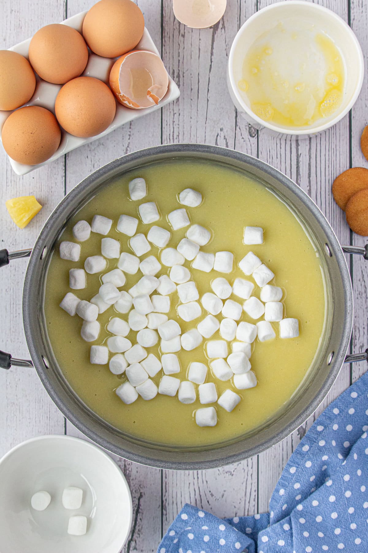 Stirring the marshmallows into the egg and pineapple filling mixture.