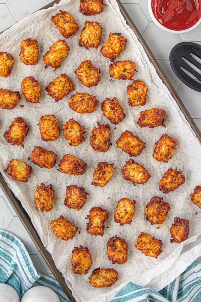 Tater tots on a baking sheet.