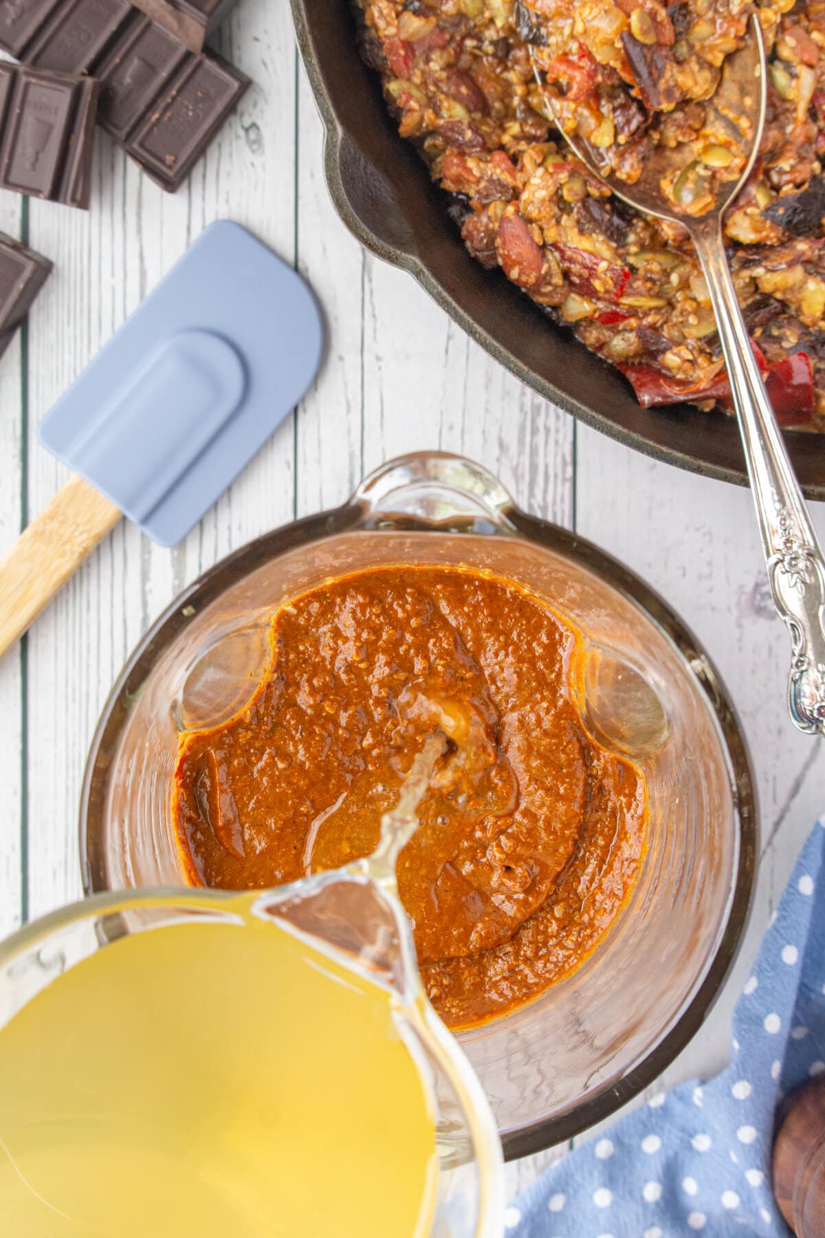 Adding more chicken stock to the mixture and blending it in a blender until smooth.