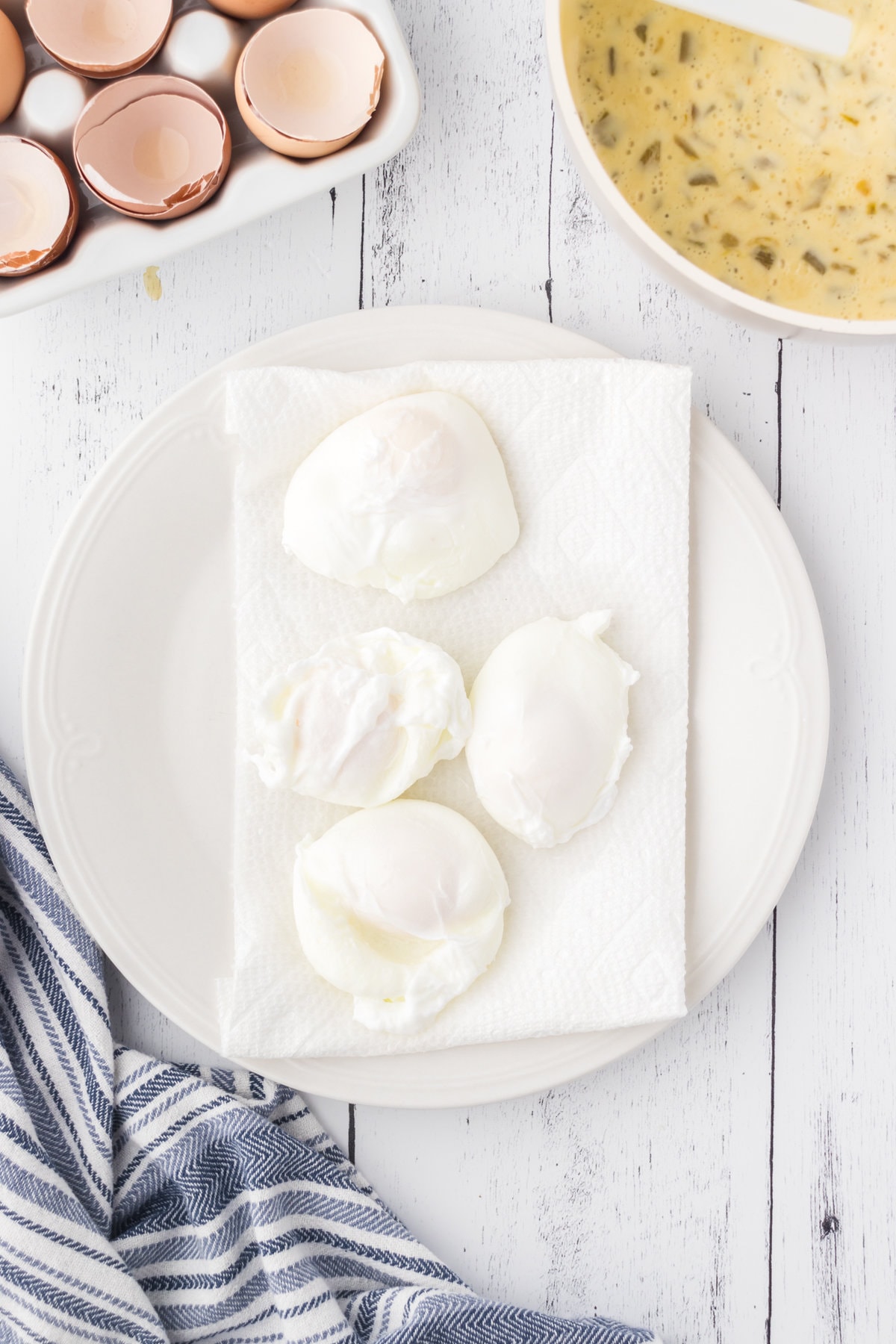 Four poached eggs being drained on a paper towel.
