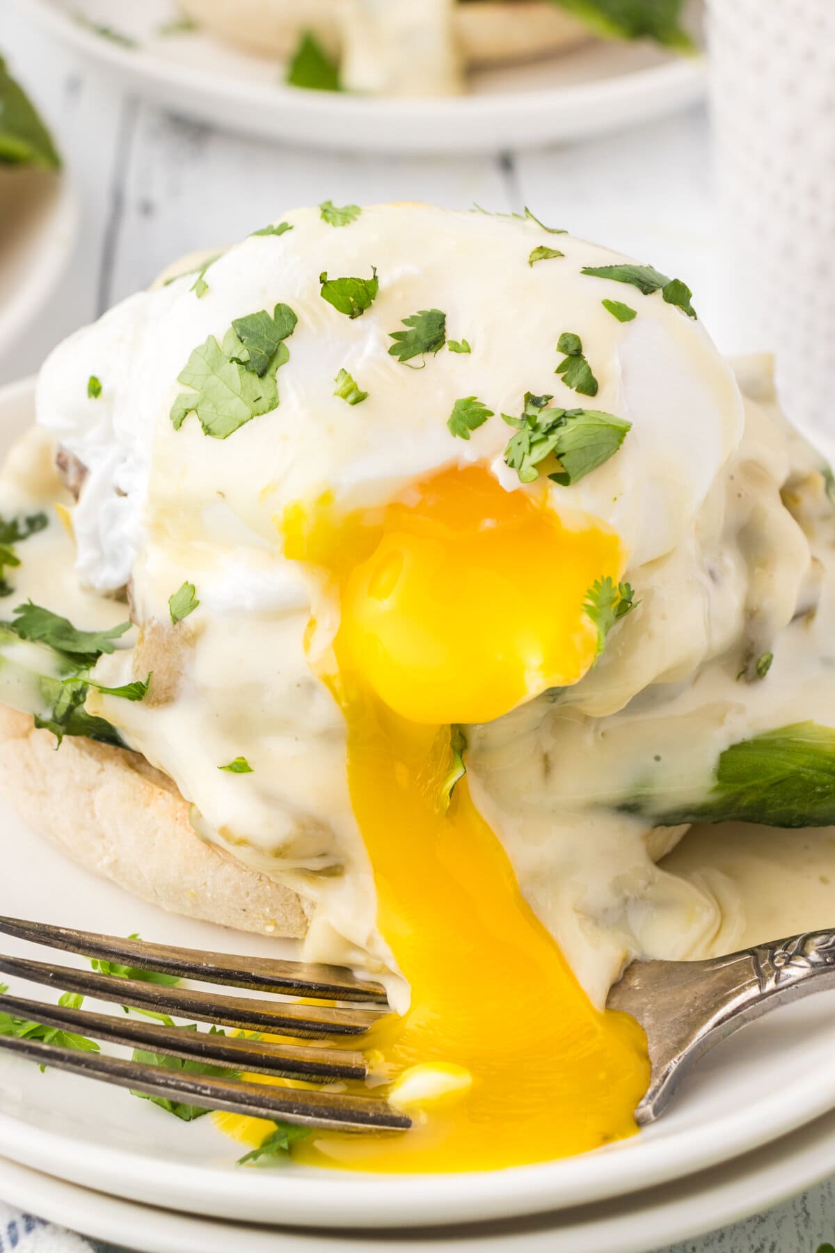 Closeup of southwestern eggs benedict with the yolk flowing over the sides.