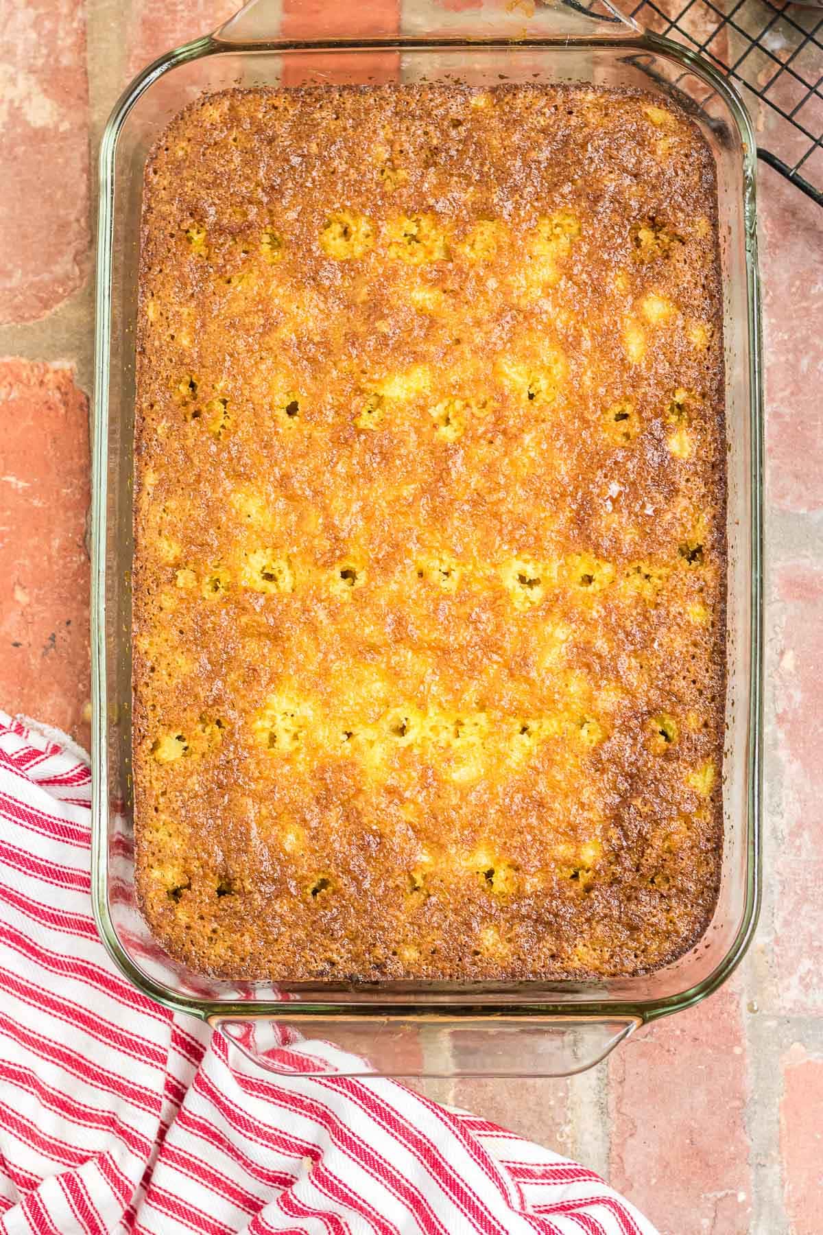 The baked cake with holes poked all over it.