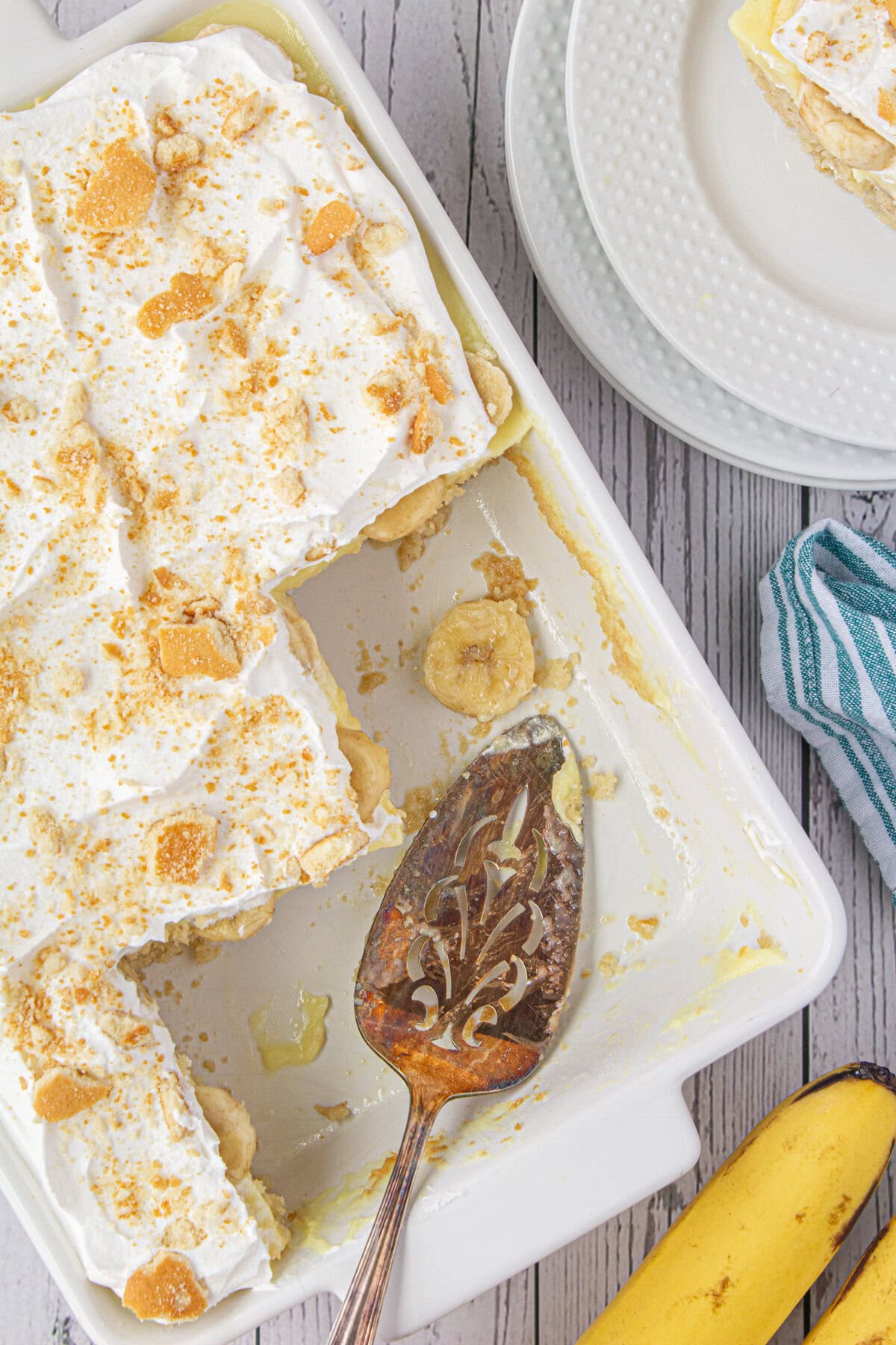 A few slices of banana pudding poke cake removed from the baking dish.