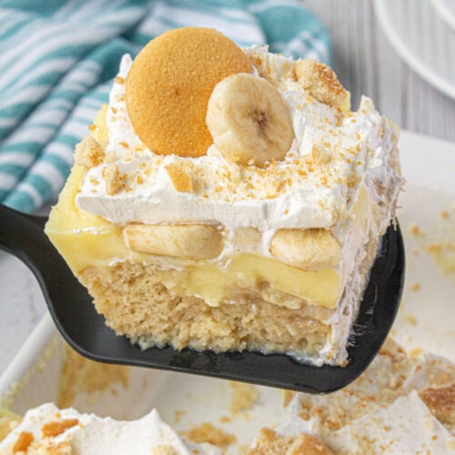 A square of cake with layers of pudding and bananas on top being served.