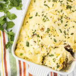 Overhead view of green chile enchiladas in a casserole dish.