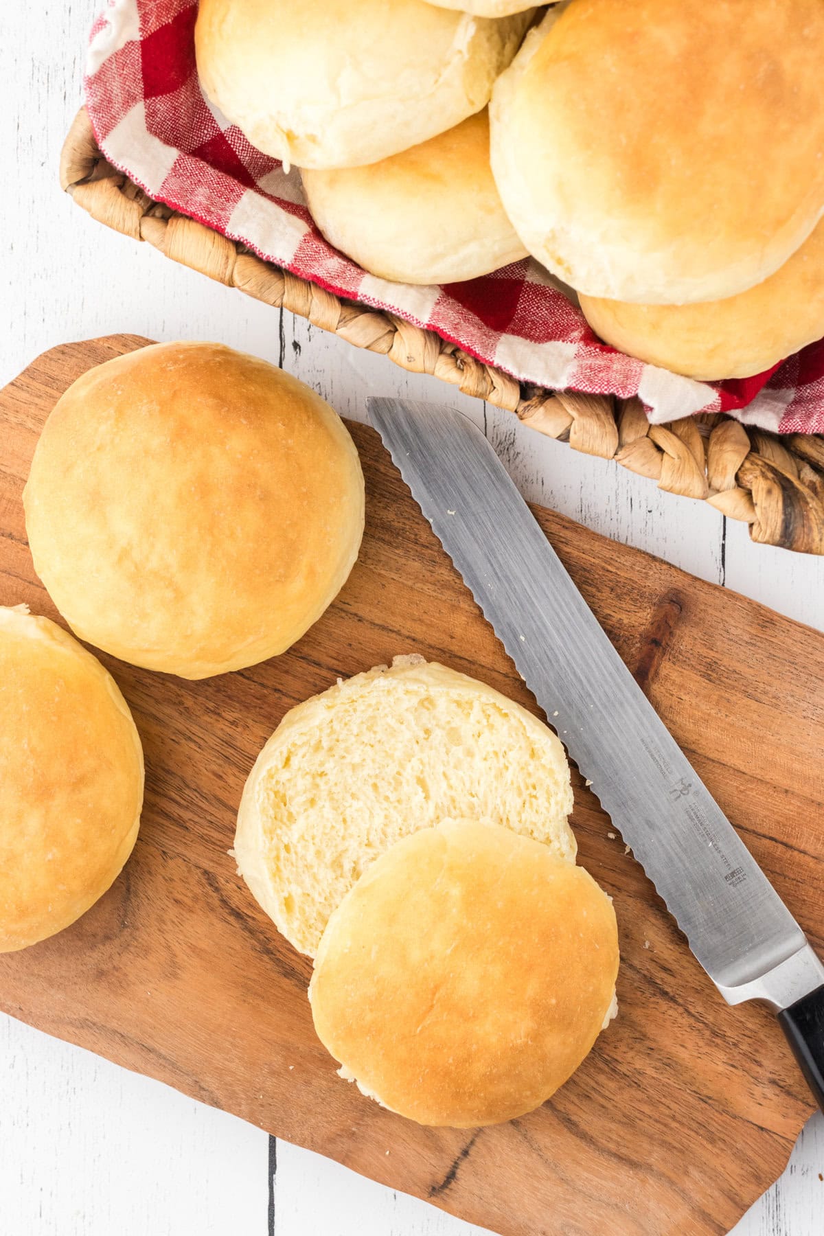 Hamburger buns sliced open on a cutting board.
