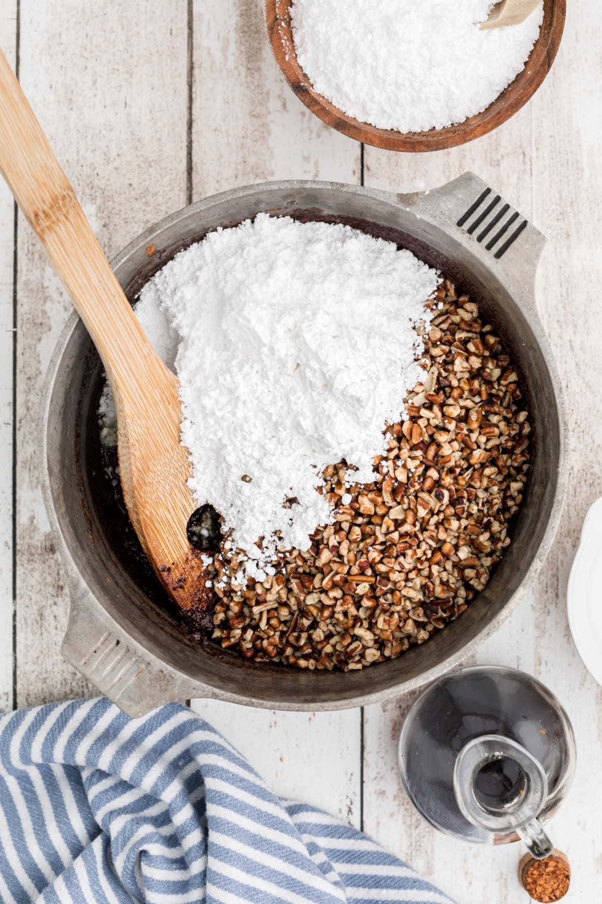 Powdered sugar and pecans are added to the pan.