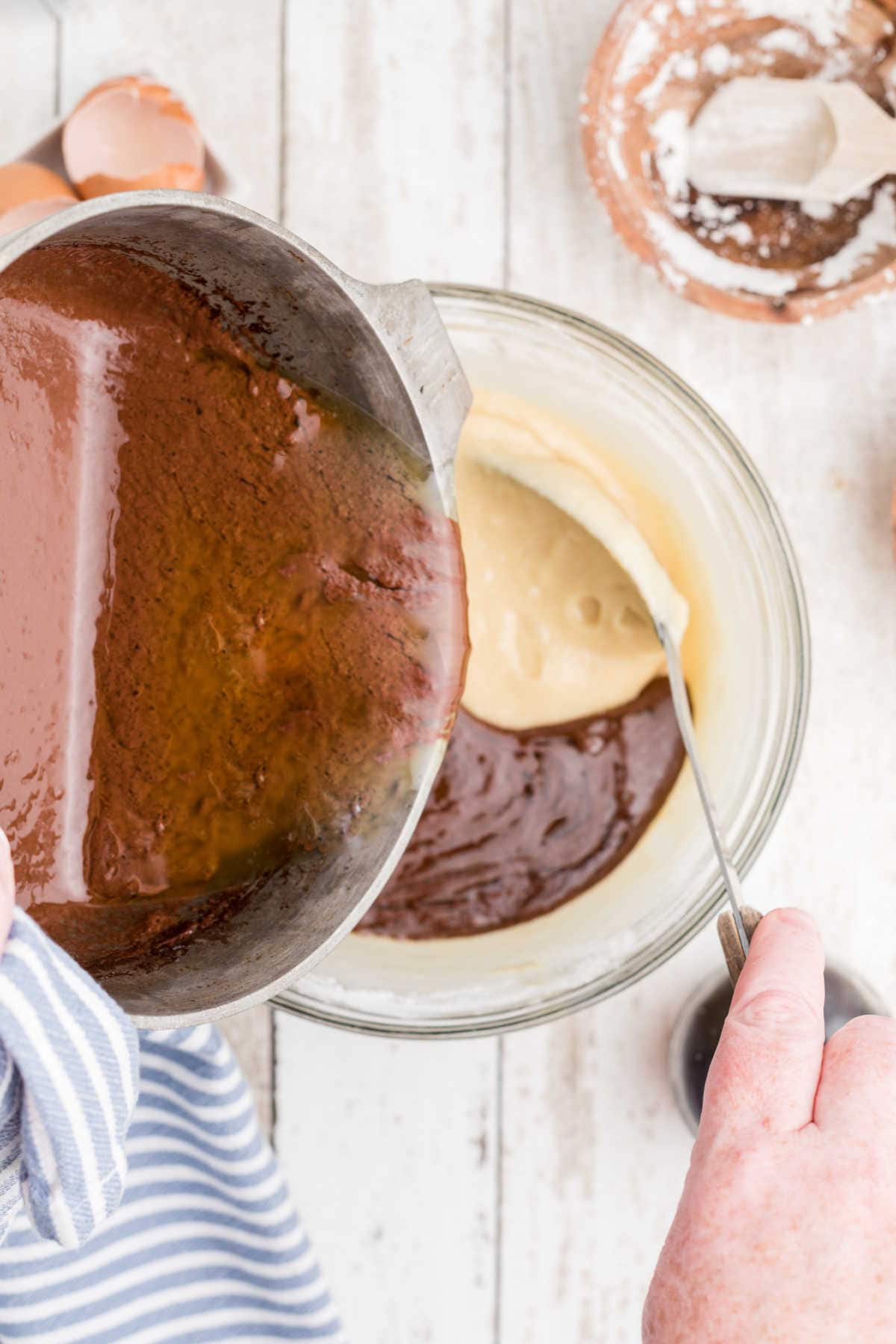 Adding the cocoa mixture to the cake batter mixture.