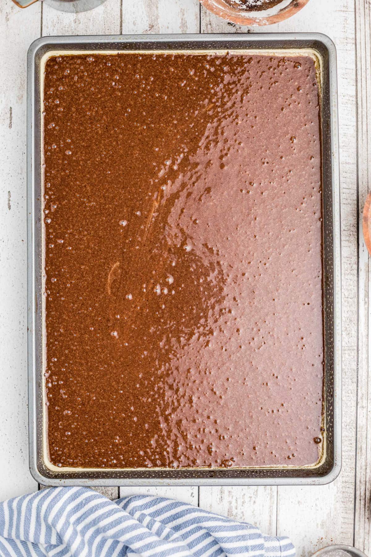 Cake batter in a high sided cookie sheet ready to bake.