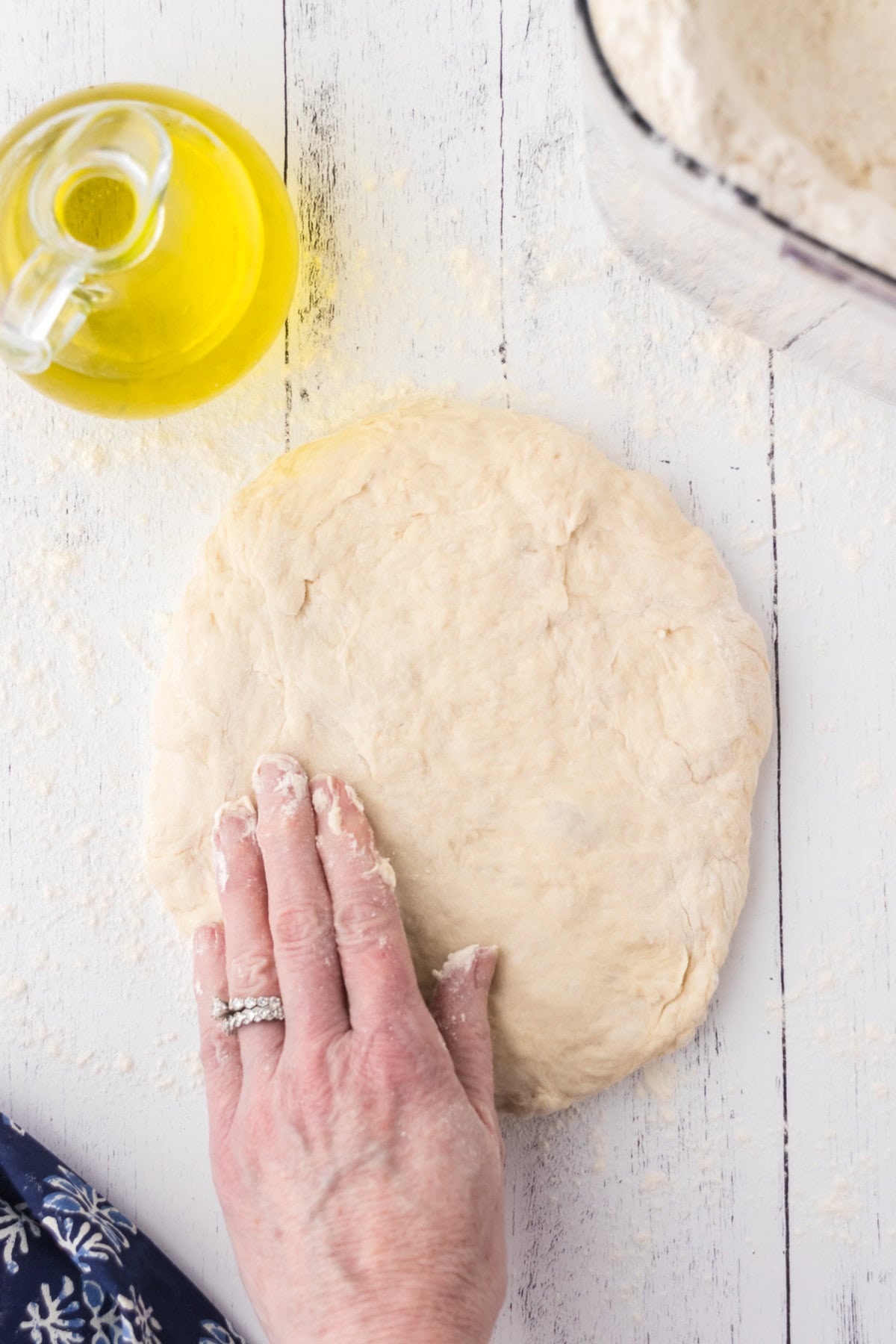 Dough being flattened into an oval.