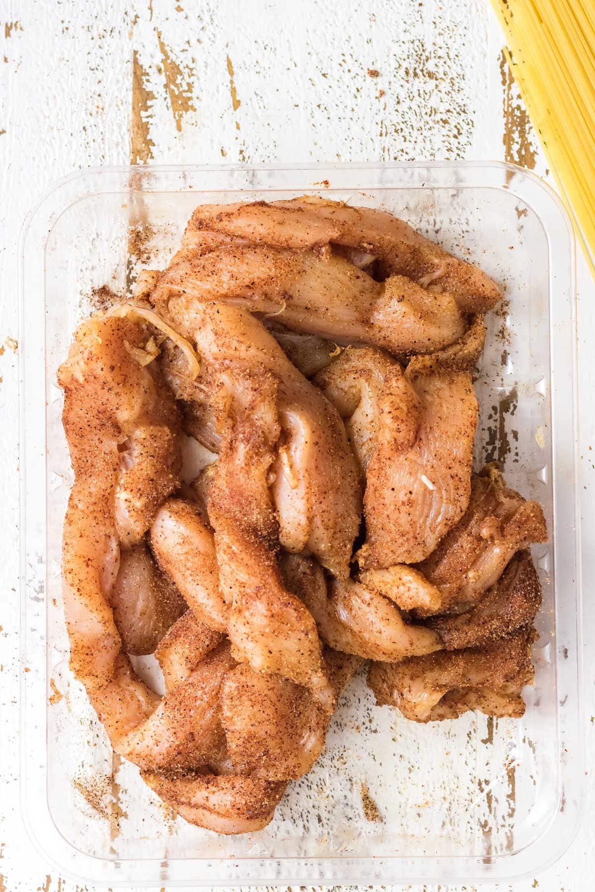 Raw chicken seasoned with cajun spices.