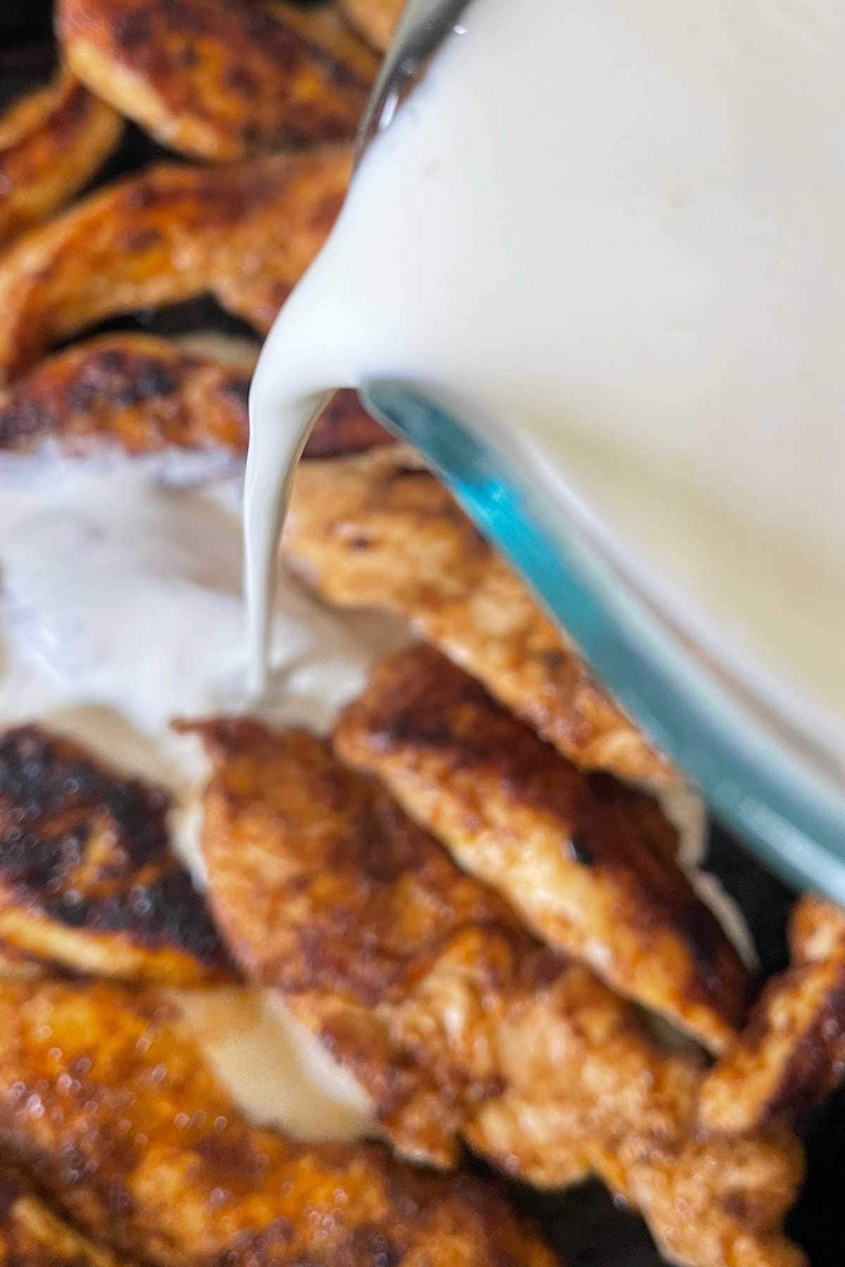 Adding the cream to the seared chicken.