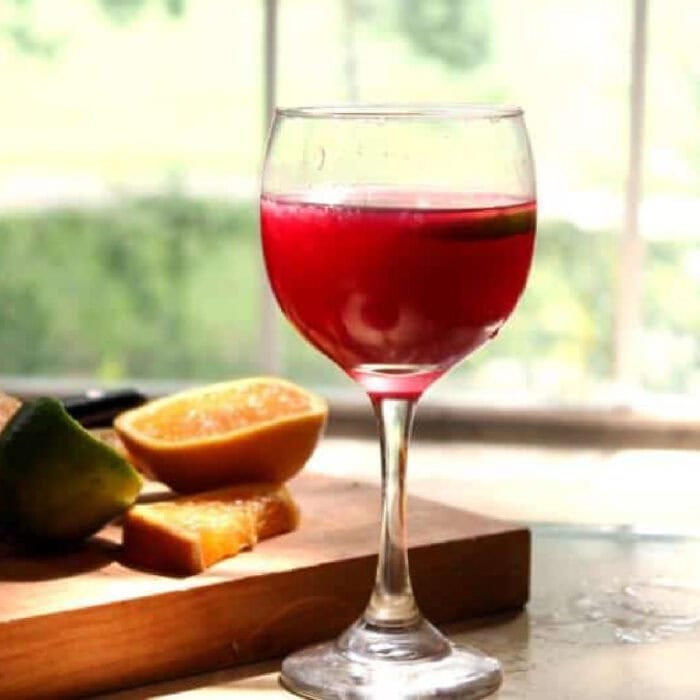A glass of red sangria on a table.
