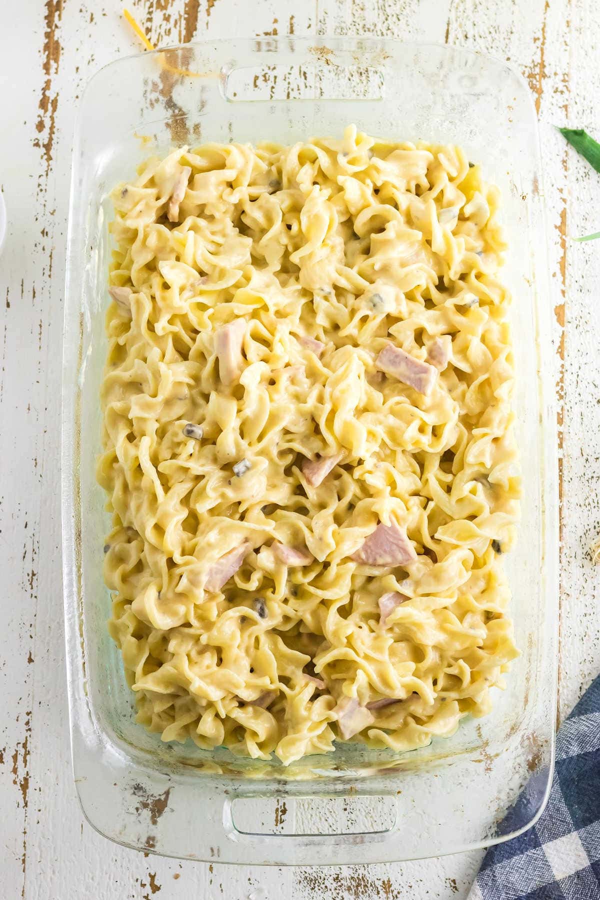 Noodle mixture in a casserole dish ready to be baked.