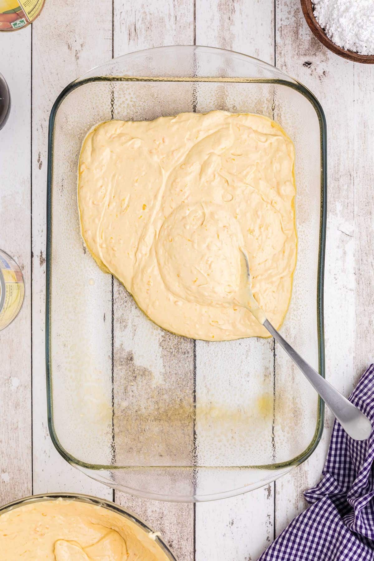 Cake batter being spread in prepared pan.