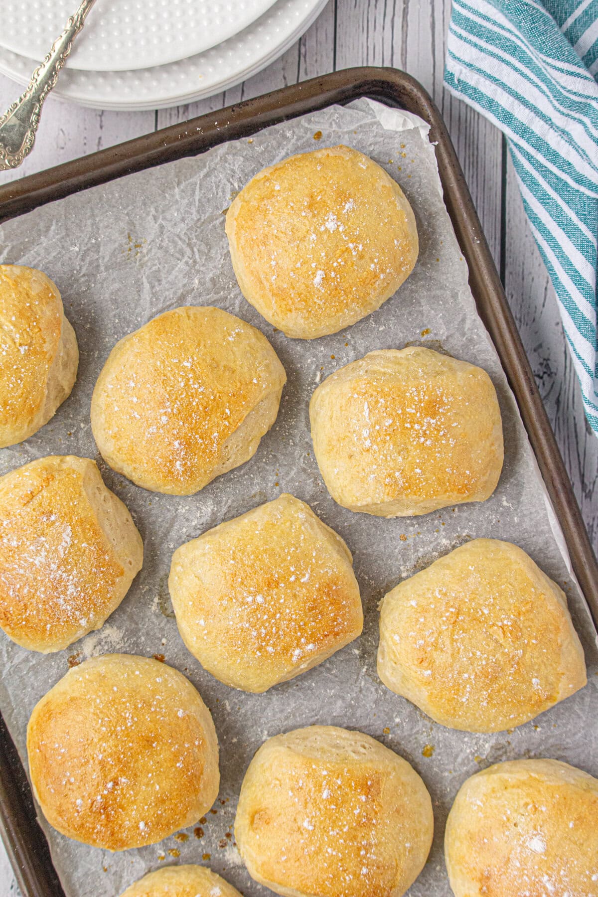Finished buttermilk dinner rolls cooling on a baking sheet.