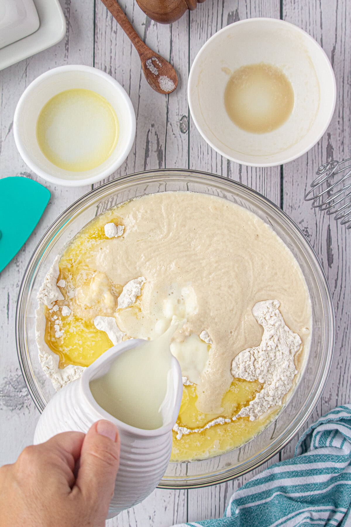 Buttermilk being added to the flour mixture in a glass bowl