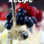 A fork stuck in a slice of cheesecake with berries on top. Title text overlay for Pinterest.