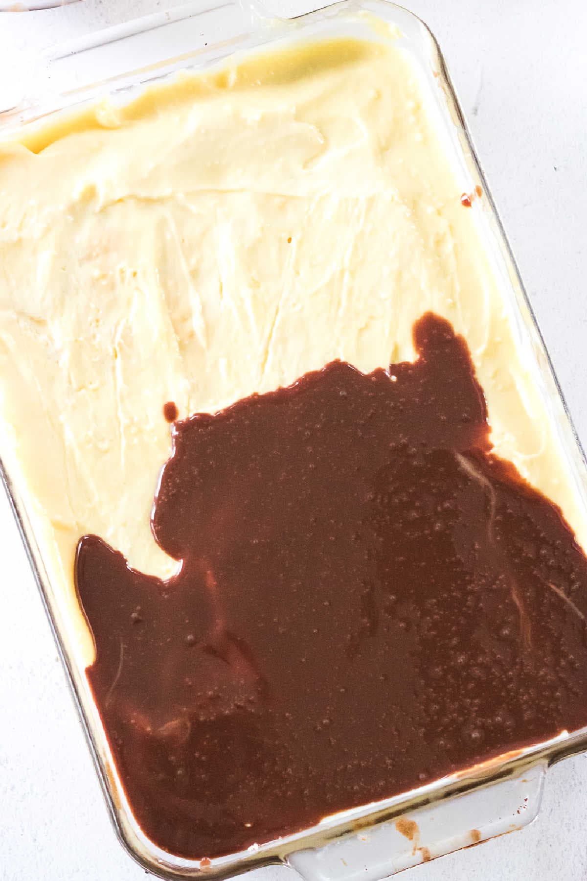 Adding chocolate glaze to top of chilled cake.