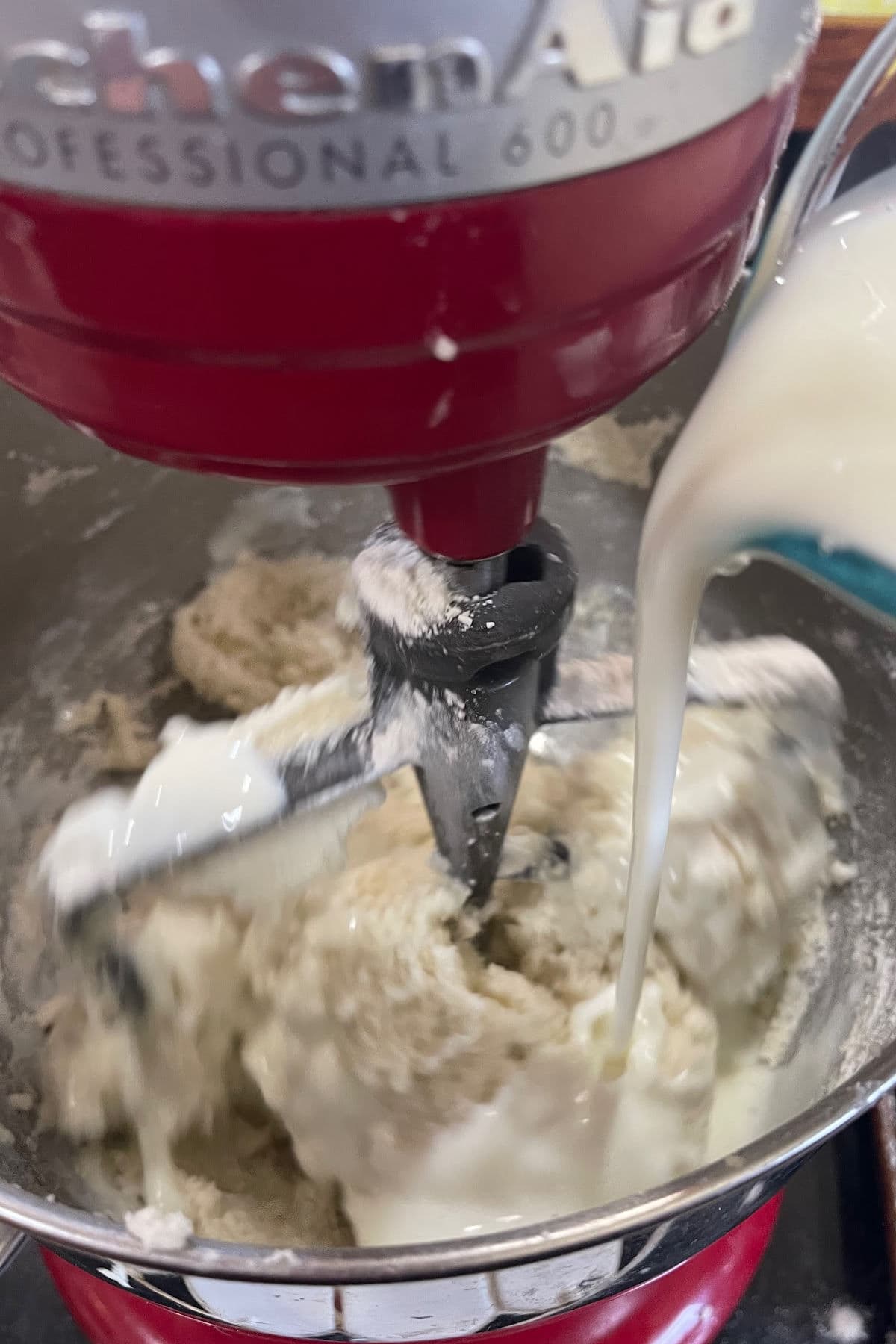 Buttermilk is being added to the mixer bowl.