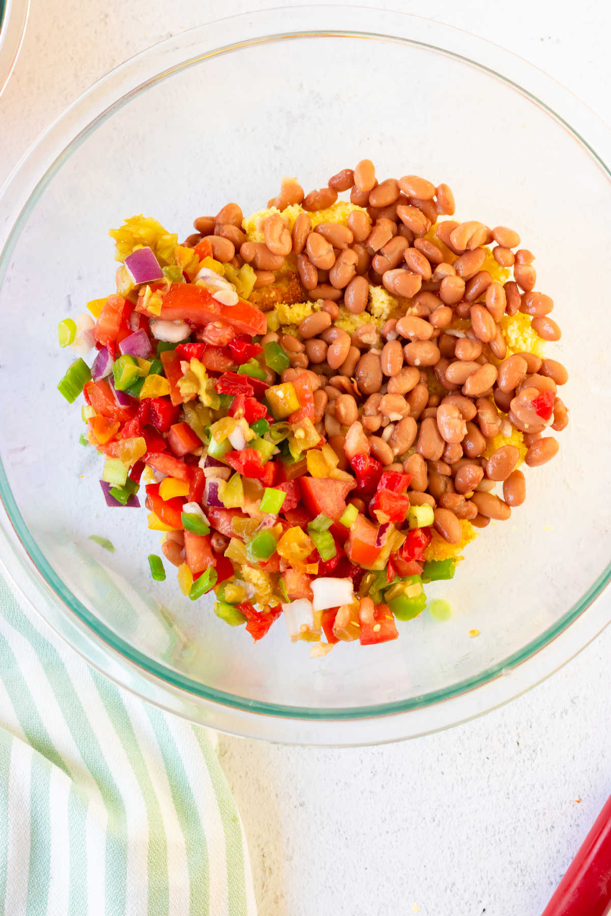 Vegetables added to a serving bowl in layers.