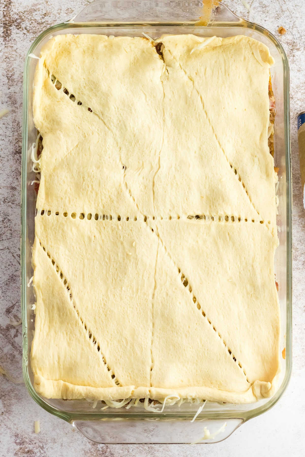 The top crust of crescent roll dough added to the casserole dish.